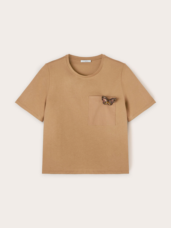 Camiseta con broche en forma de mariposa