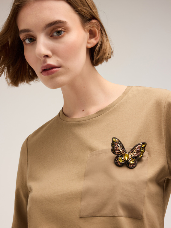 Camiseta con broche en forma de mariposa